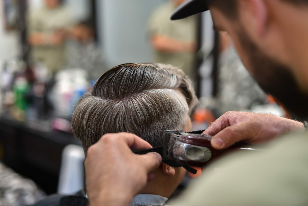 Men's haircut in barbershop. Hair Care. Barber cuts the client.